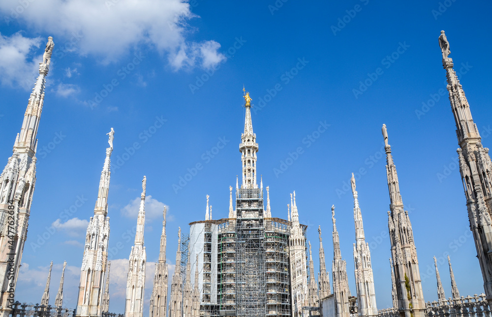 Spires and Golden Madonna (Madonnina statue) at the roof of Milan Cathedral (Duomo di Milano) Lombardy region, Italy. Spires and Golden Madonna (Madonnina statue) at the roof of Milan Cathedral (Duomo di Milano) Lombardy region, Italy.