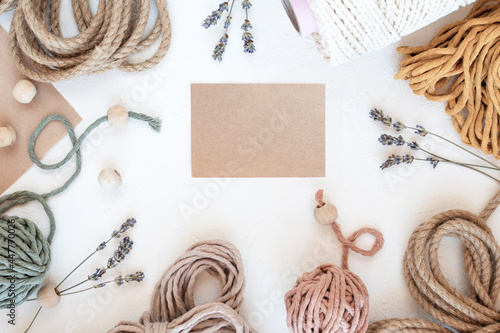 Beautiful layout of materials for macrame: cotton cords, jute twine, wooden beads. Flat lay, copy space.