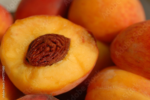 Healthy vegetarian fruit for breakfast on summer. Sweet peaches dessert. One peach cut in half. Diet concept. Macro.