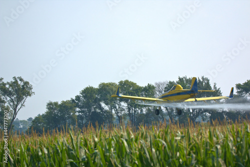 Low flying Crop Duster applying insecticide to the corn fields