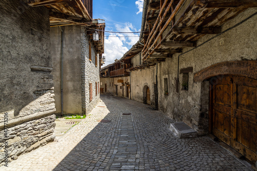 A cobbled street in Chianale, with typical wooden houses. Chianale is one of the most beautiful alpine village of Italy. photo