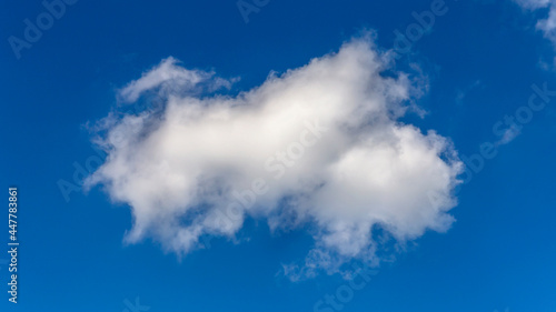 large textured cumulus cloud against blue summer sky as a natural background