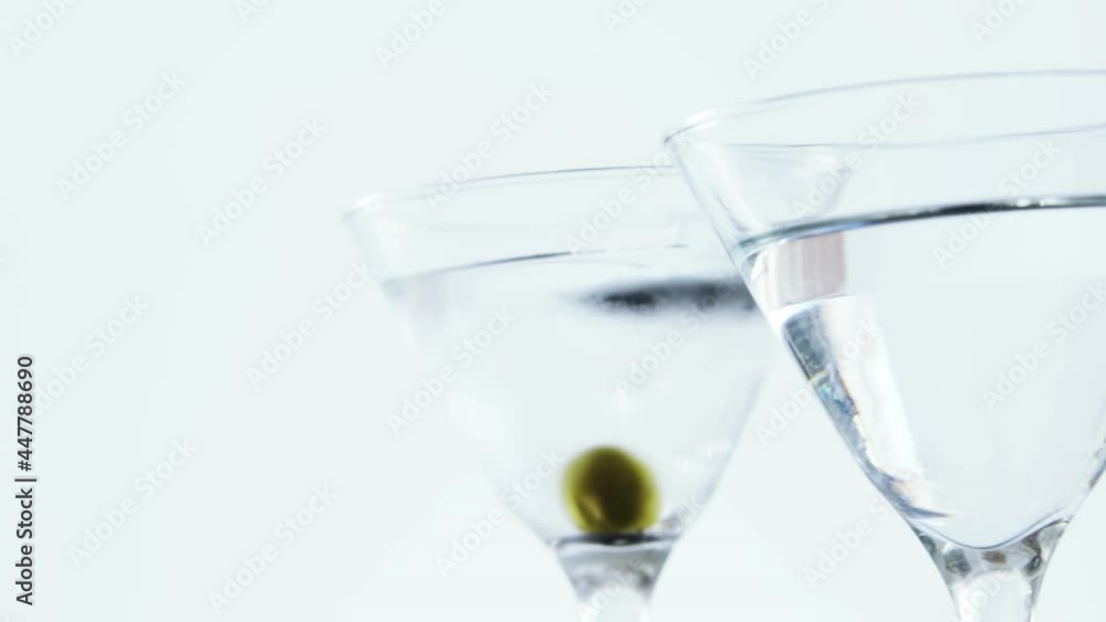 Animation of red specks moving over cocktail glasses with olives on white background Animation of red specks moving over cocktail glasses with olives on white background