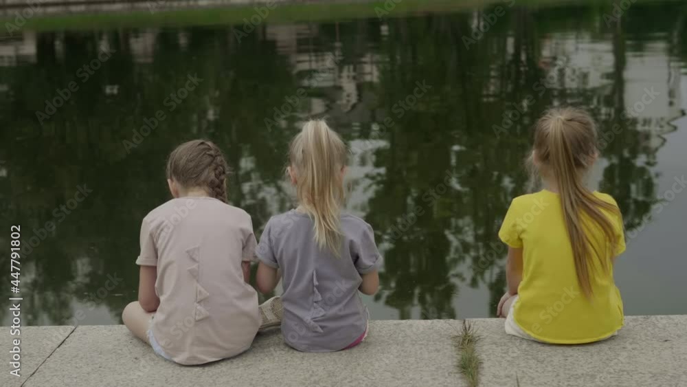 Children by the pond eating ice cream Children by the pond eating ice cream