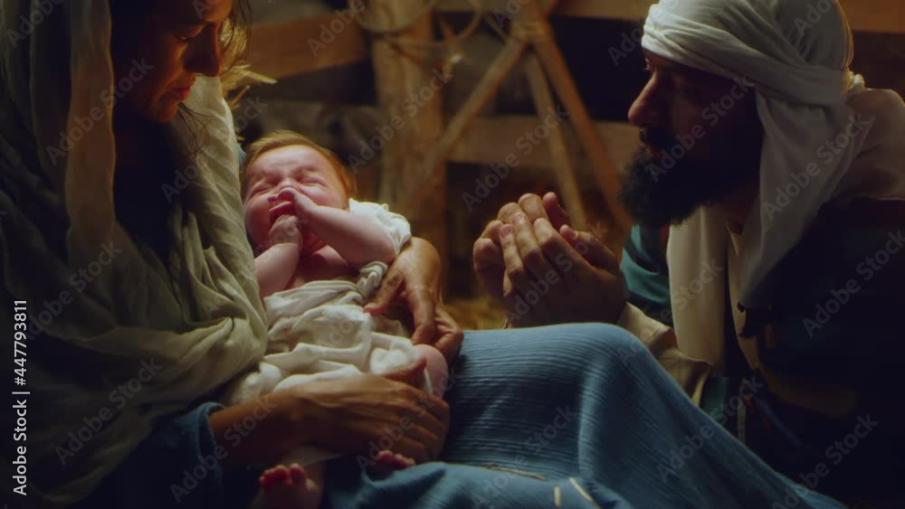 Joseph and Mary with crying baby Jesus near stalls nativity scene Joseph and Mary with crying baby Jesus near stalls nativity scene