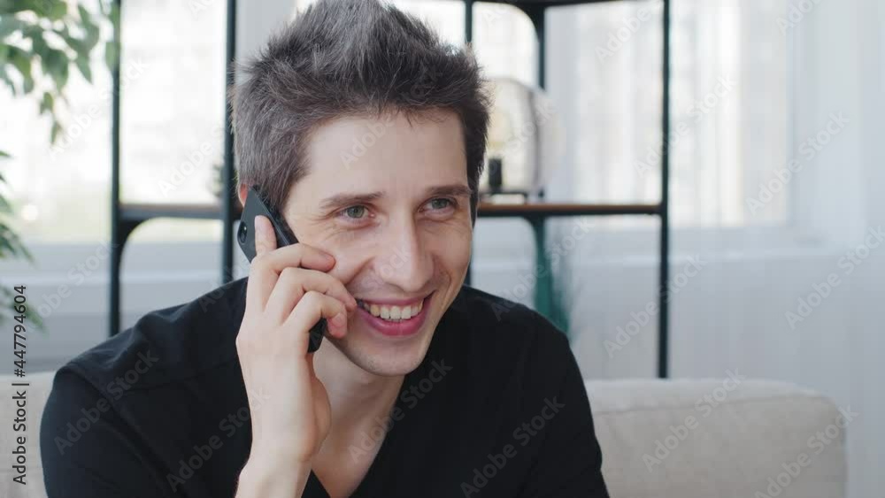 Portrait caucasian adult seductive man wearing black t-shirt talking on mobile phone with girlfriend emotionally answering call using smartphone cellphone smiling finishing conversation with air kiss Portrait caucasian adult seductive man wearing black t-shirt talking on mobile phone with girlfriend emotionally answering call using smartphone cellphone smiling finishing conversation with air kiss