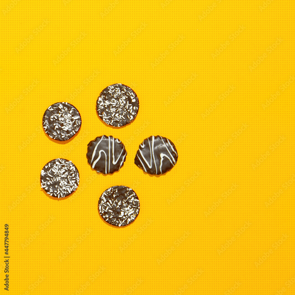 Chocolate cookies on yellow paper background. Minimal art. Holidays time, winter christmas celebration, diet, calorie, sweet shop concept. Flat lay art Chocolate cookies on yellow paper background. Minimal art. Holidays time, winter christmas celebration, diet, calorie, sweet shop concept. Flat lay art