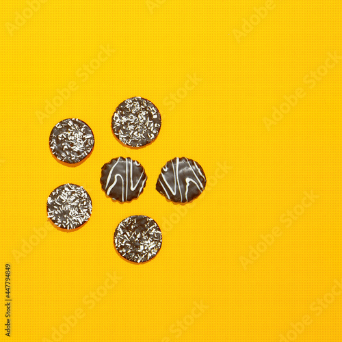 Chocolate cookies on yellow paper background. Minimal art. Holidays time, winter christmas celebration, diet, calorie, sweet shop concept. Flat lay art