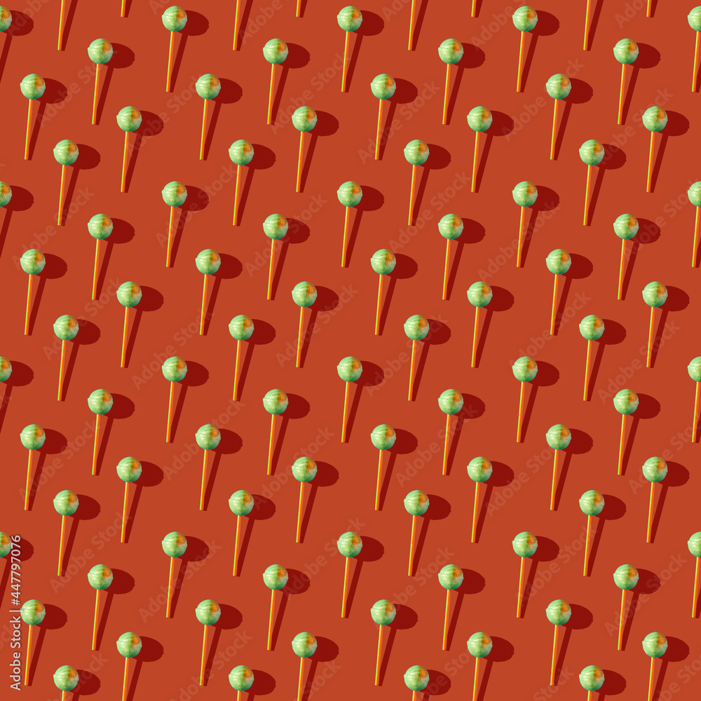 Photo in the form of a seamless pattern. Candy on a stick with shadows on a colored orange background. High quality photo Photo in the form of a seamless pattern. Candy on a stick with shadows on a colored orange background. High quality photo