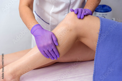 Cosmetic procedure applying cream on the legs depilation epilation rubbing cream skin softening
