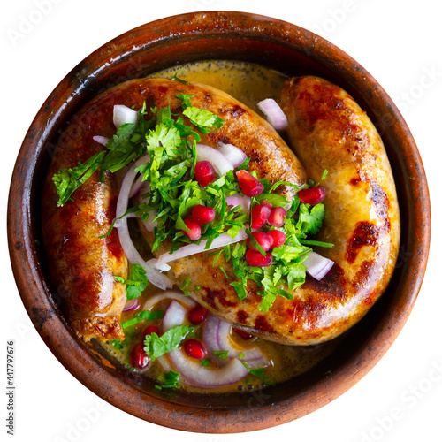 Spicy grilled sausages garnished with cilantro, onion and pomegranate, authentic dish of Georgian cuisine Kupaty. Isolated over white background