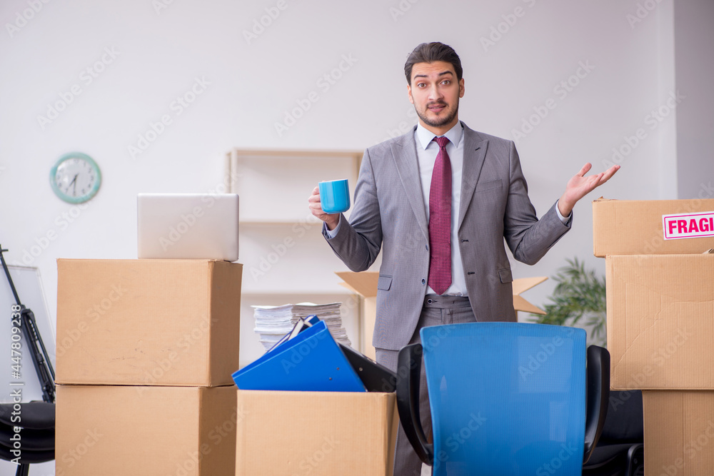 Young male employee in relocation concept Young male employee in relocation concept