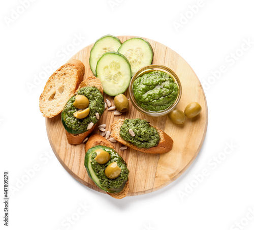 Tasty toasts with pesto sauce and olives on white background