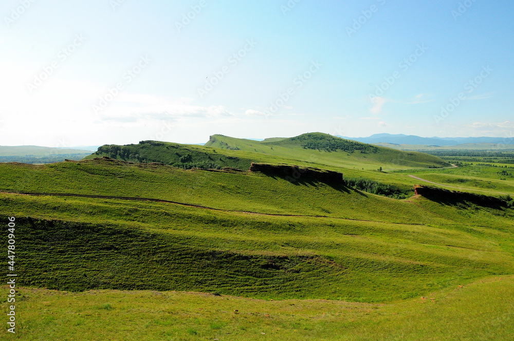 High hills and hollows in the endless steppe under a clear summer sky on a clear sunny day. High hills and hollows in the endless steppe under a clear summer sky on a clear sunny day.