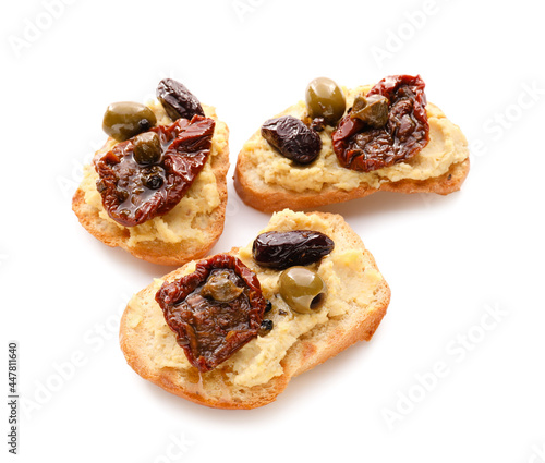 Tasty bruschettas with sun-dried tomatoes and hummus on white background