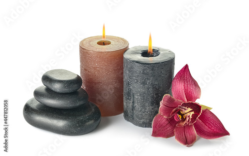 Composition with burning candles, spa stones and orchid flower on white background