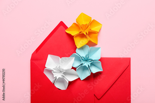 Origami daffodils and envelopes on color background