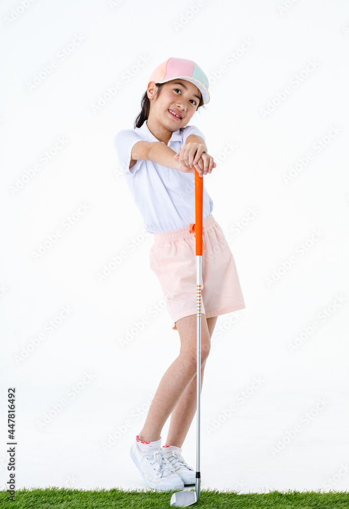 Portrait isolated studio shot of pretty cute little Asian golfer in sport uniform and colorful cap stand on green grass posing put hands on orange grip of golf club driver in front white background Portrait isolated studio shot of pretty cute little Asian golfer in sport uniform and colorful cap stand on green grass posing put hands on orange grip of golf club driver in front white background