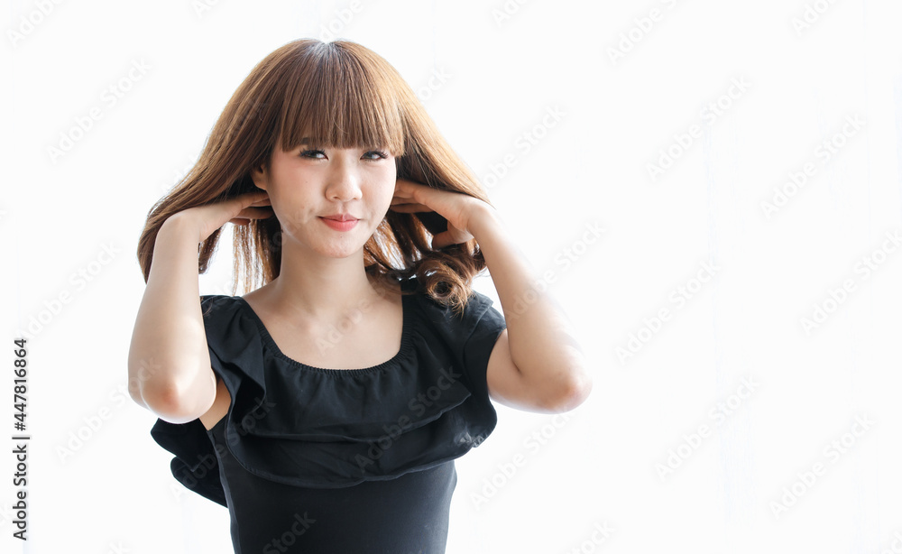 Lovely cute Asian woman in black dress using her hand to gather brunette hair and play on it with happy and funny for show her beautiful hairstyle Lovely cute Asian woman in black dress using her hand to gather brunette hair and play on it with happy and funny for show her beautiful hairstyle