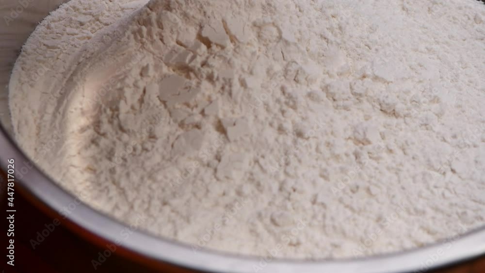 Female hands pouring wheat flour and corn flour into a stainless container to mixing, prepares batter for homemade corndogs. Cooking process. Female hands pouring wheat flour and corn flour into a stainless container to mixing, prepares batter for homemade corndogs. Cooking process.