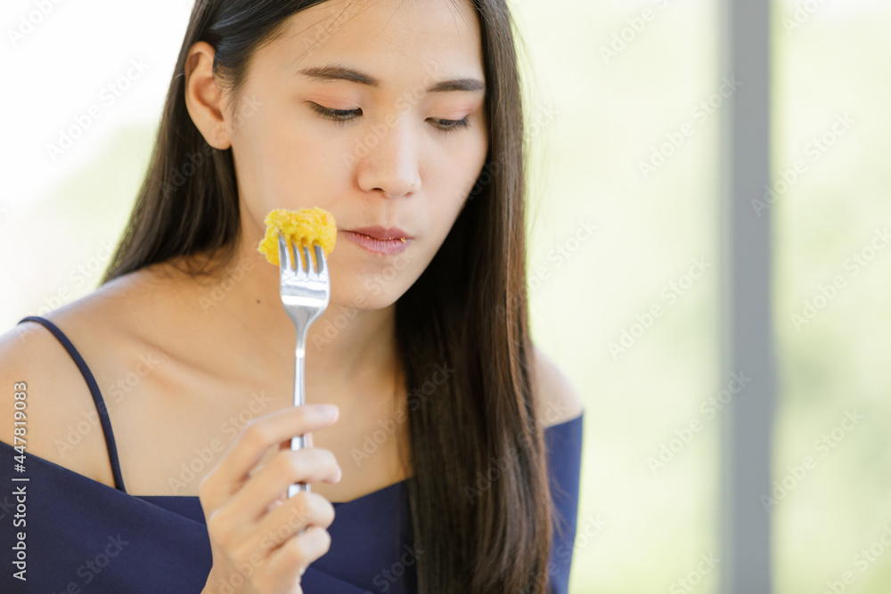 A beautiful young cute black long hair Asian woman try to test a food A beautiful young cute black long hair Asian woman try to test a food