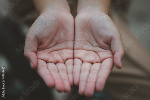 Close-up of both hands of a child who is holding hands in hopes of receiving something. photo