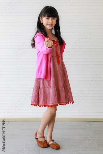 Wallpaper Mural Little adorable sweet cheerful Asian girl wearing pink clothes, pretty joyful smiling with happiness, posing, standing and looking at camera. Torontodigital.ca