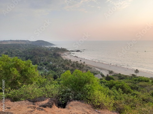 Summer beach with people. Men and women doing vacation activities, swimming lying and sitting. people with Beach Activities in Sunny Day, Vagator Beach. photo