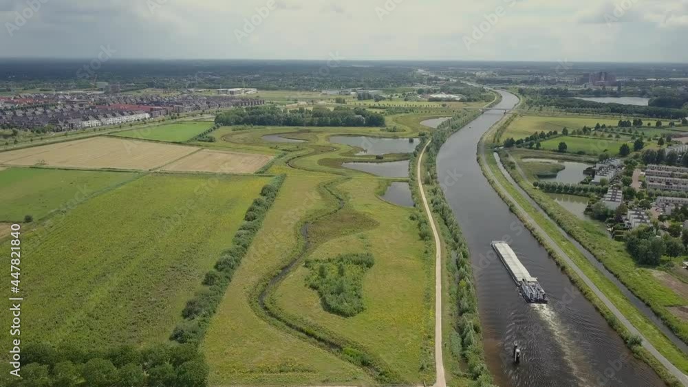 Aerial drone view of the epic scene at the canal and shipping boat passing in the Netherlands, Europe. Aerial drone view of the epic scene at the canal and shipping boat passing in the Netherlands, Europe.