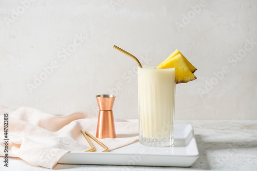 Glass with tasty Pina Colada cocktail on light background photo