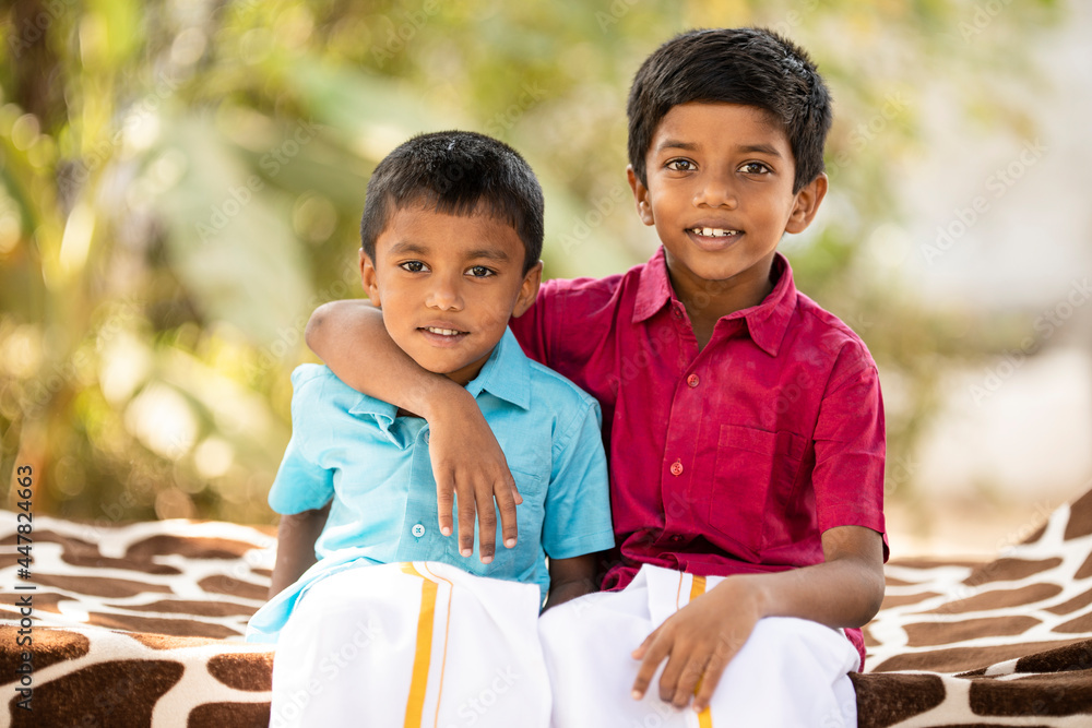 Cute Indian little brothers posing in traditional dress at outdoor