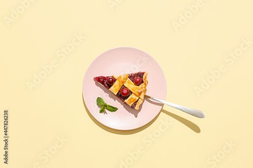 Plate with piece of tasty cherry pie on color background