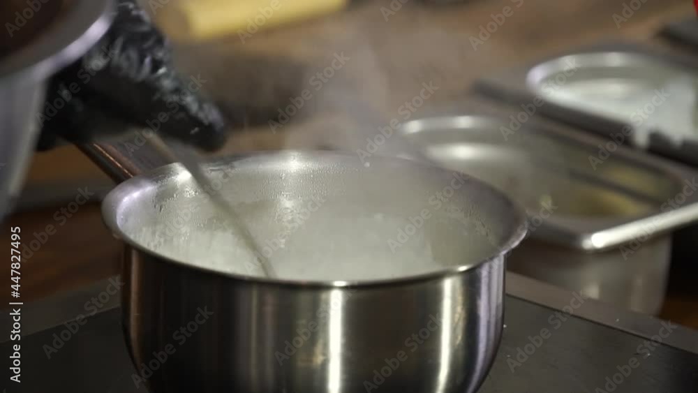 The cook prepares the sauce on the stove The cook prepares the sauce on the stove
