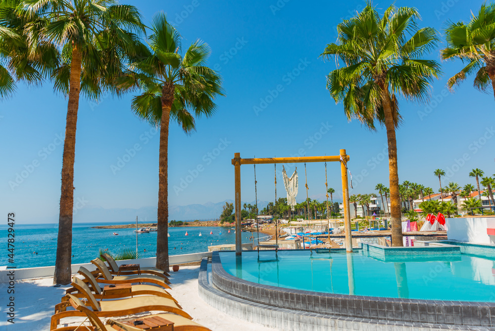 Naklejka premium ANTALYA, TURKEY: Swimming pool and swing on the territory of Fosforlu beach on a sunny day.