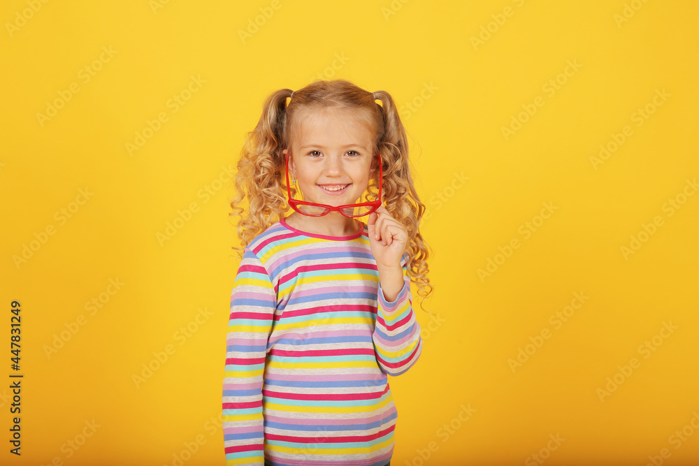 a beautiful blonde girl with ponytails and a multi-colored T-shirt with red-rimmed glasses a beautiful blonde girl with ponytails and a multi-colored T-shirt with red-rimmed glasses