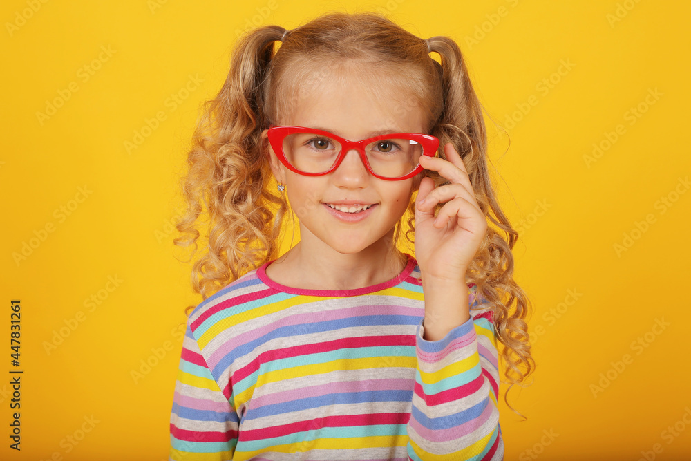 a beautiful blonde girl with ponytails and a multi-colored T-shirt with red-rimmed glasses