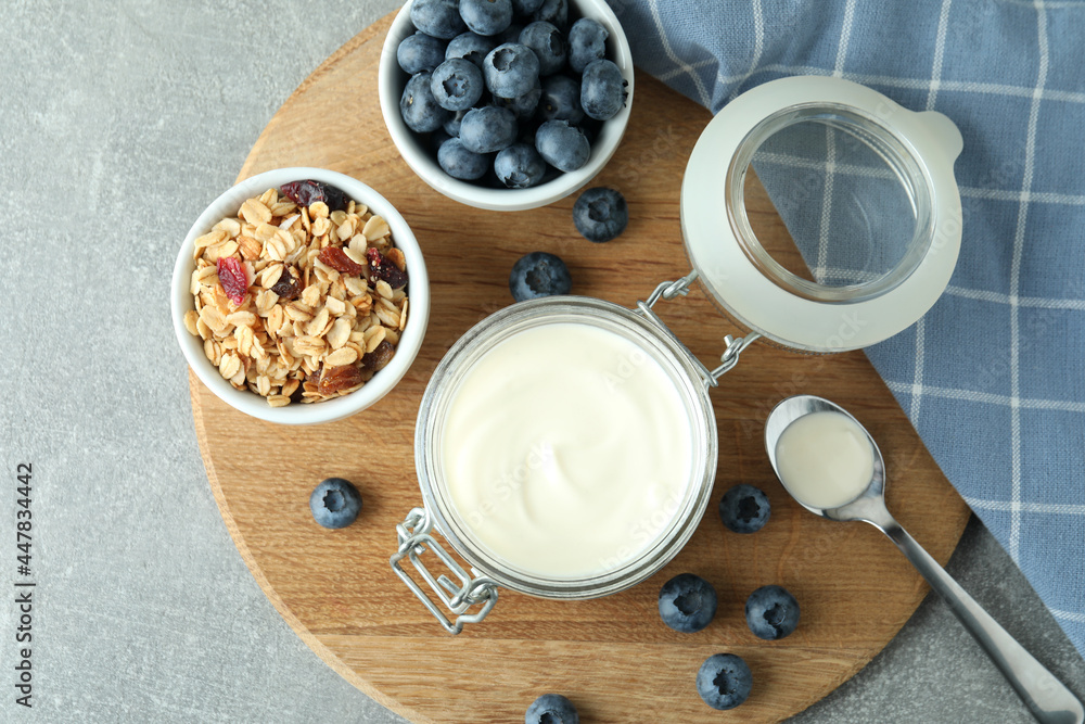 Concept of tasty breakfast with yogurt on gray textured table Concept of tasty breakfast with yogurt on gray textured table