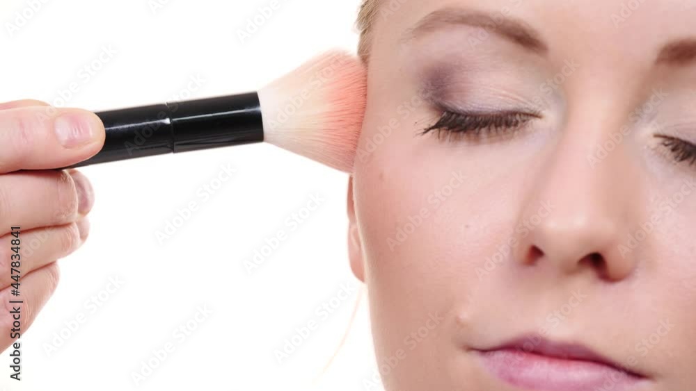 Woman face painting. Makeup artist applying blush with brush to model cheek. Cosmetic beauty procedures and makeover concept. Slow motion Woman face painting. Makeup artist applying blush with brush to model cheek. Cosmetic beauty procedures and makeover concept. Slow motion
