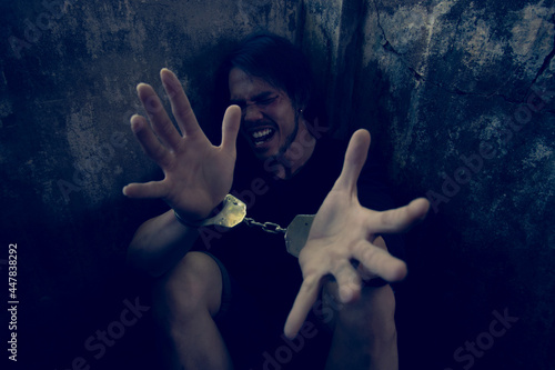 Depressed and hopeless asian man sitting alone after using drugs sitting on the floor. Drugs addiction and withdrawal symptoms concept.