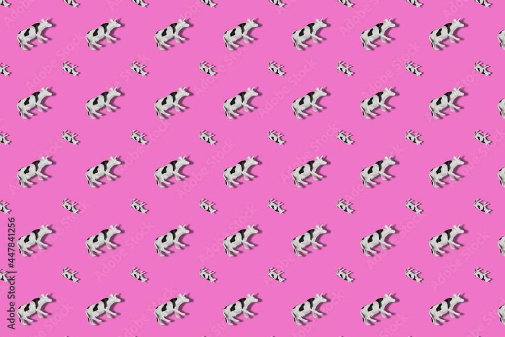 Repeating Toy Cow on a colored background. Black and white spott