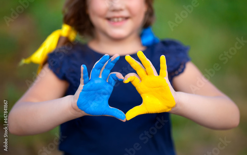 Love Ukraine concept. Little girl show hands in heart form painted in Ukraine flag color - yellow and blue. Independence day of Ukraine, Flag, Constitution day Education, school, art painitng concept photo