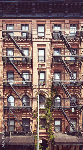 New York old townhouse with iron fire escape, color toning applied, USA.