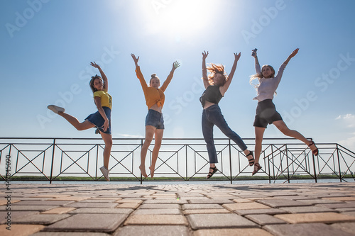 four women are photographed jumping in the summer