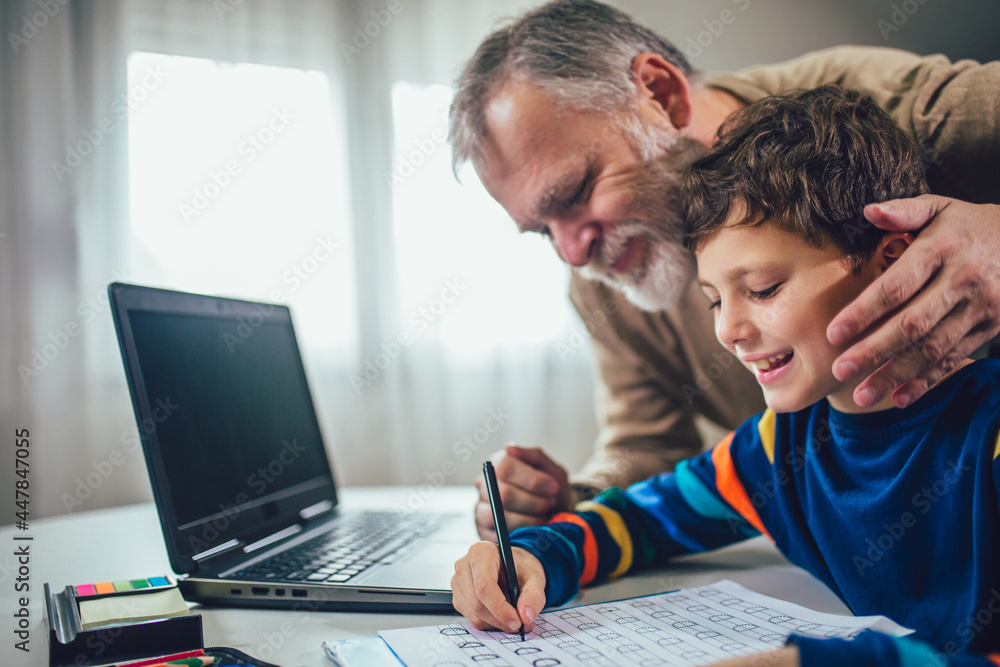 Child practicing writing at home with the help of his father Child practicing writing at home with the help of his father