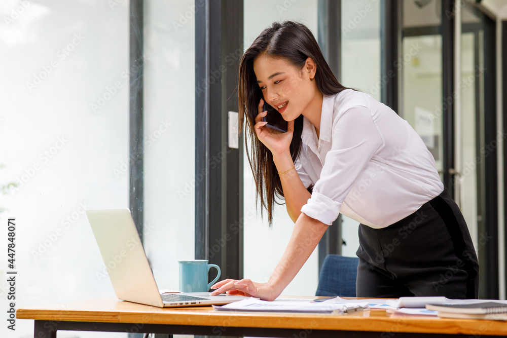Obraz premium Portrait of beautiful Young asian businesswoman sitting at desk and using laptop in work office,Successful confident japanese female office worker,