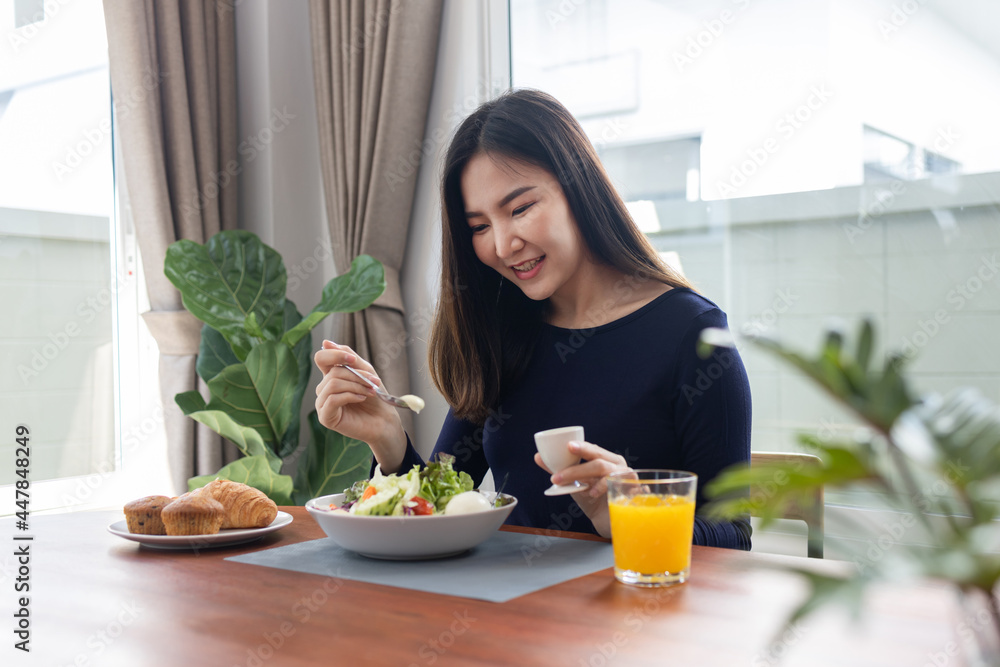 Having meal concept a pretty woman mixing zero calories salad dressing with a green salad in the bowl Having meal concept a pretty woman mixing zero calories salad dressing with a green salad in the bowl