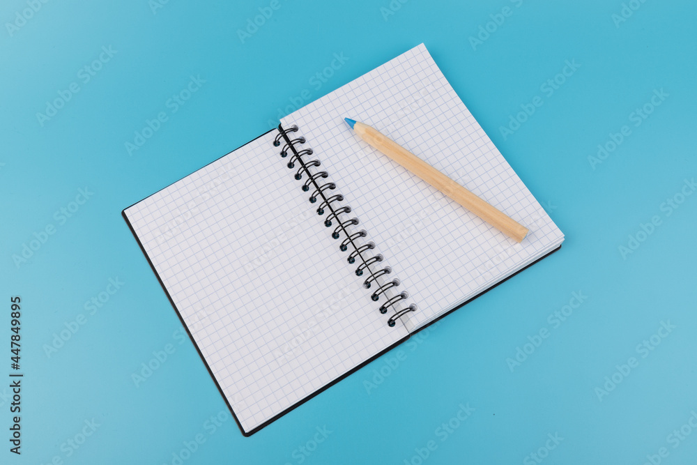 Blank paper and pencil on a blue background