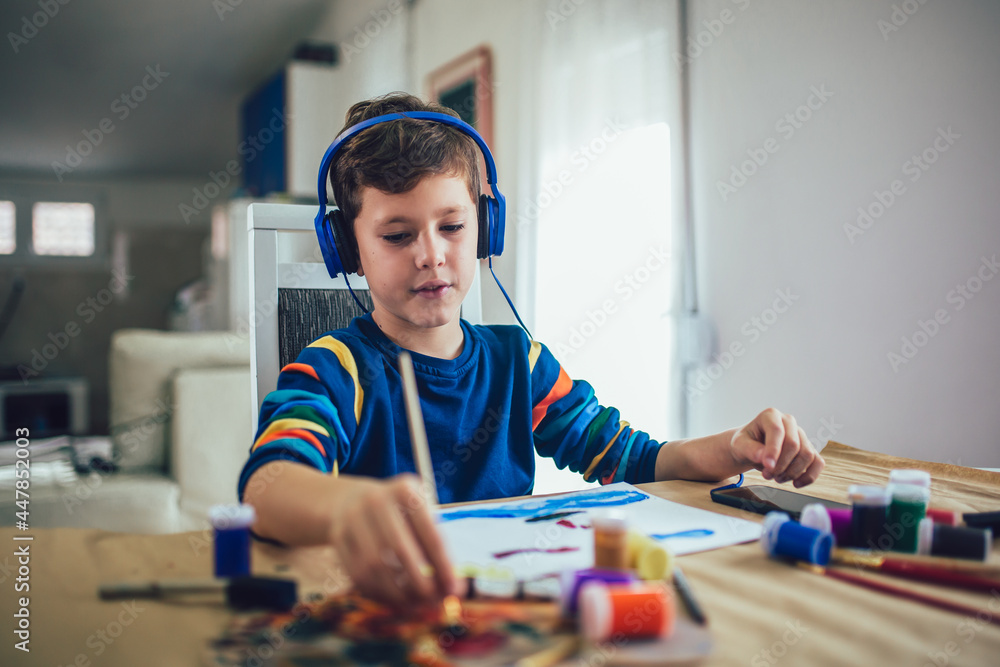 Fototapeta premium Cute little boy painting a picture in home studio