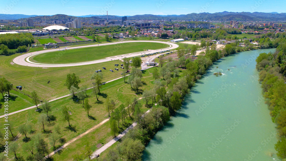 Obraz na płótnie AERIAL: Flying along emerald Sava river and toward a hippodrome near Ljubljana. w salonie