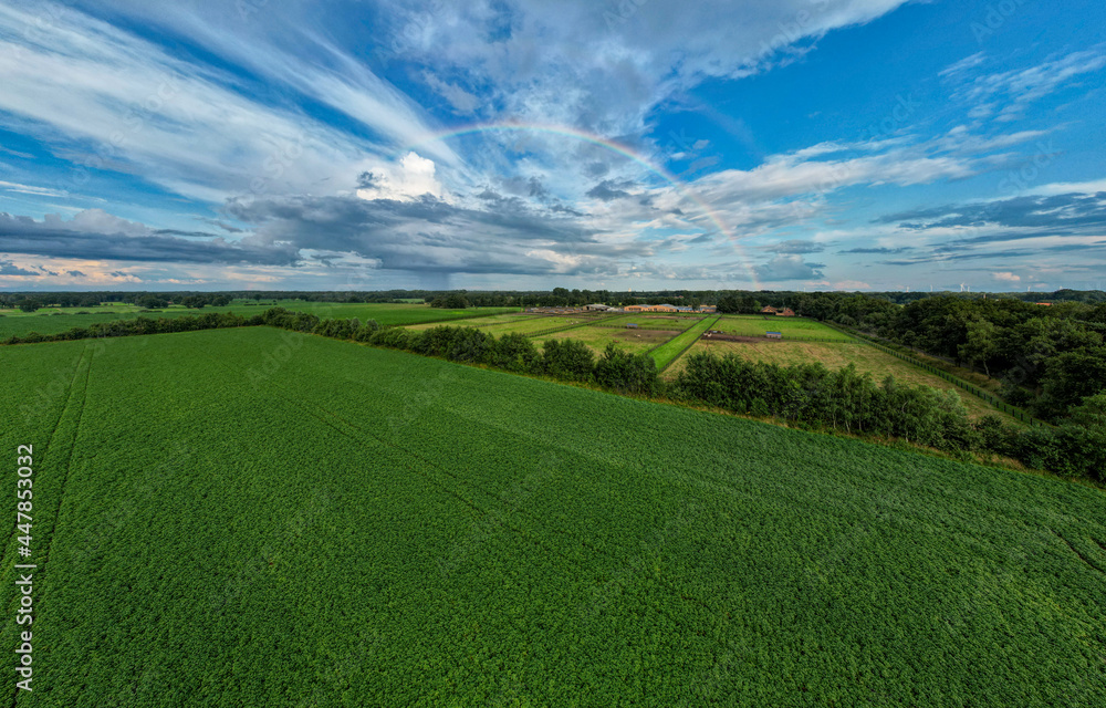 Aerial panorama view shot with drone of a rainbow over stormy sky. Rural landscape with rainbow over dark stormy sky in a countryside at summer day. High quality photo Aerial panorama view shot with drone of a rainbow over stormy sky. Rural landscape with rainbow over dark stormy sky in a countryside at summer day. High quality photo